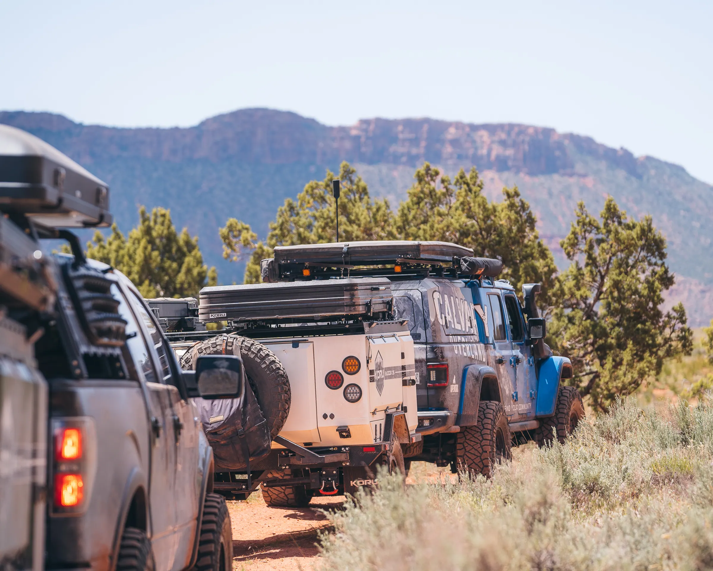 Trucks and trailers staged beneath a mesa