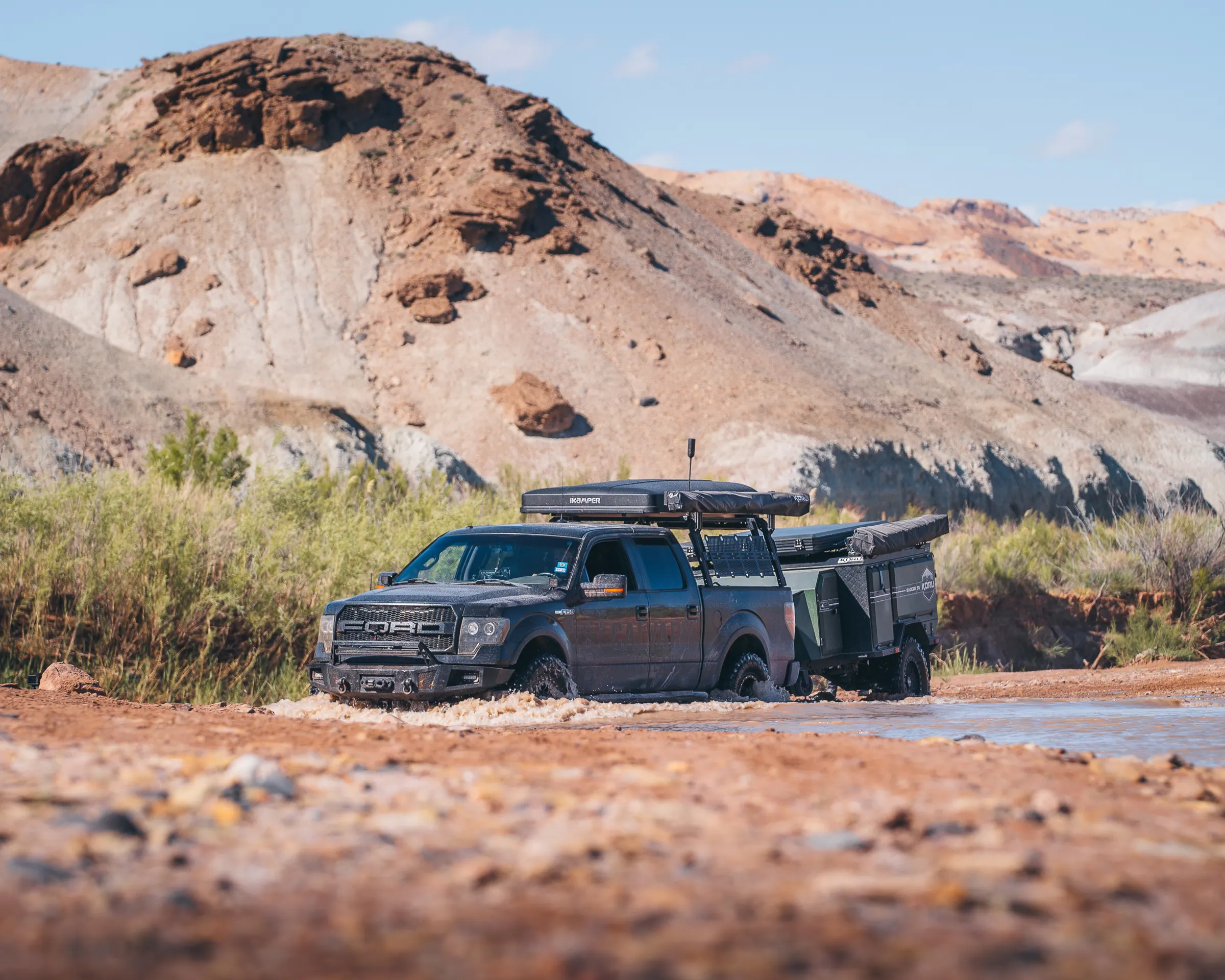 A truck and Koru trailer at a desert river